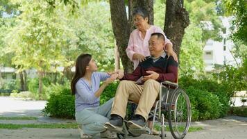 une fille prise se soucier de le patient dans une fauteuil roulant et parler avec maman. concept de content retraite avec se soucier de une soignant et des économies et Sénior santé assurance, content famille et retraite photo