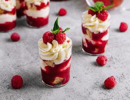 en couches dessert bagatelle avec vanille gâteau, fouetté crème et Frais framboises photo