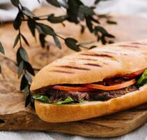 sandwich avec Viande et des légumes sur une en bois planche photo