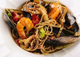 Fruit de mer Pâtes spaghetti avec crevettes, squis, moule et tomates photo