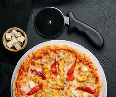 chaud délicieux traditionnel italien Pizza sur une foncé pierre Contexte photo