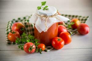 cuit fait maison tomate jus en conserve dans une pot de Naturel tomates. photo