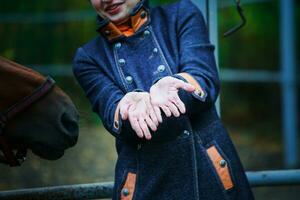 une femme spectacles sale mains. mains de le ouvrier après se soucier de les chevaux. photo