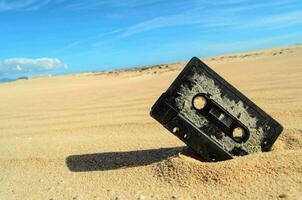 une cassette est enterré dans le le sable sur une plage photo