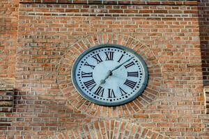 une l'horloge sur le côté de une brique bâtiment photo