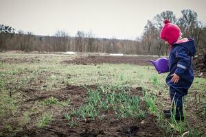 adorable fille arrosage les plantes dans jardin photo