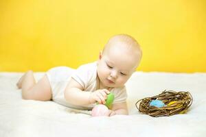 enfant coups un Pâques Oeuf sur un autre. Oeuf tapotement. bébé avoir amusement sur Pâques photo