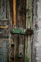 un vieux fermer à clé charnière sur une fissuré en bois porte. ancien porte photo