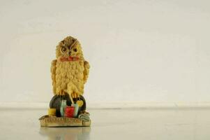 une petit figurine de un hibou séance sur une table photo