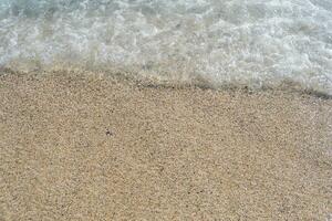une doux vague court sur une sablonneux rive sur une été journée. photo