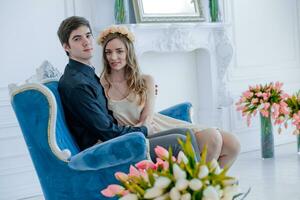 gars avec fille dans blanc pièce sont séance sur bleu canapé. photo