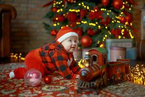 peu fille suivant à Noël train. content enfant dans Père Noël chapeau près cadeaux sur Contexte de Nouveau année arbre dans de fête chambre. 6 mois vieux bébé est souriant. magnifique peu fille attendre pour Noël présente. photo