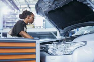 mécanicien dans voiture un service choix couple clé de travail station banc, en utilisant il à serrer boulons après remplacer radiateur. qualifié bipoc garage ouvrier les usages professionnel outils à réparer client voiture photo