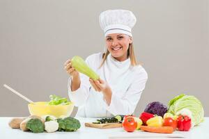 femelle chef montrant Zucchini tandis que fabrication en bonne santé repas photo