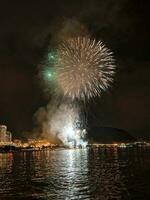 coloré feux d'artifice dans le nuit ciel sur le front de mer de alicante Espagne photo