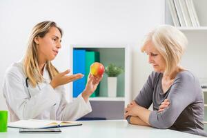 Sénior femme patient refusant à manger fruit lequel est bien pour sa santé photo