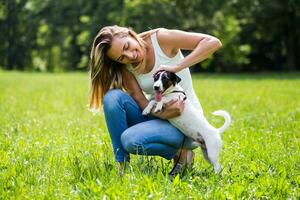 magnifique femme jouit dépenses temps dans le la nature avec sa mignonne chien jack Russell terrier photo