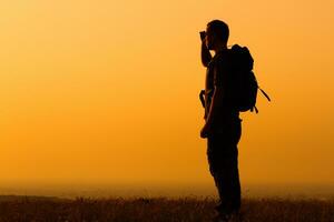 promeneur jouit en train de regarder le coucher du soleil photo