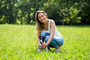 magnifique femme jouit dépenses temps dans le la nature avec sa mignonne chien jack Russell terrier photo