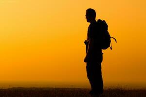 promeneur jouit en train de regarder le coucher du soleil photo