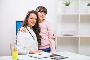 femelle médecin et enfant embrassement à le médical Bureau photo