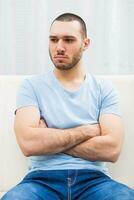 en colère Jeune homme séance à canapé photo