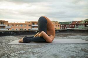 femme pratiquant yoga sur le toit photo