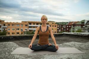 femme pratiquant yoga sur le toit photo