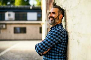 portrait de moderne homme d'affaire avec barbe permanent dans de face de mur Extérieur photo