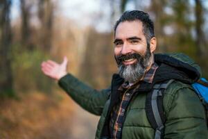 image de promeneur montrant Bienvenue geste tandis que randonnée dans la nature photo