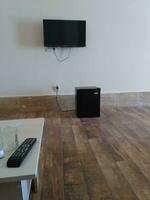 la télé éloigné contrôle dans moderne vivant pièce avec parquet sol et blanc mur photo
