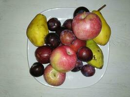 assiette de Frais fruit sur une en bois tableau. Haut voir. photo