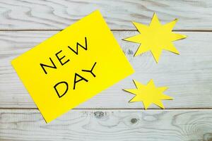 Nouveau journée concept avec Jaune gluant Remarque et étoile papier sur en bois Contexte photo