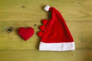 rouge Père Noël chapeau et une cœur sur une en bois table photo