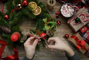 Noël Accueil décoration, femelle mains en portant une couronne, main fait. joyeux Noël. plat poser.haut qualité photo