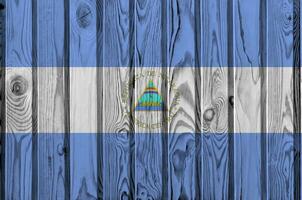 Nicaragua drapeau représenté dans brillant peindre couleurs sur vieux en bois mur. texturé bannière sur rugueux Contexte photo