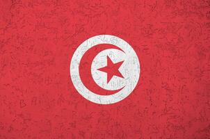 drapeau tunisien représenté dans des couleurs de peinture vives sur un vieux mur de plâtrage en relief. bannière texturée sur fond rugueux photo