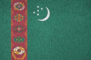 drapeau du turkménistan représenté dans des couleurs de peinture vives sur un vieux mur de plâtrage en relief. bannière texturée sur fond rugueux photo