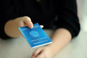 femme patron donne une brésilien travail carte et social Sécurité bleu livre à nous dans emploi Bureau photo