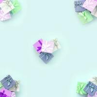 des piles de petites boîtes-cadeaux colorées avec des rubans se trouvent sur un fond violet. modèle de vue de dessus à plat minimalisme photo
