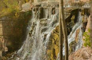 magnifique cascade entre grand rochers dans l'automne forêt. sofievski parc dans homme, Ukraine photo