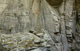 fond de pierre de roche naturelle grossière légère. surface avant rugueuse de la falaise minière. toile de fond de grande pile de calcaire. grunge lourd texture de bloc de granit endommagé photo