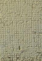 la texture de l'ancien mur de béton, avec un revêtement de tuiles peu profondes de forme carrée, peintes en gris. image de fond d'un mur de nombreux carreaux blancs carrés photo