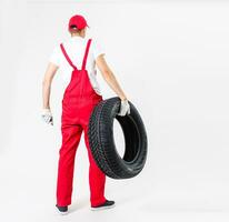 travail homme dans plein croissance détient une pneu sur une blanc Contexte photo