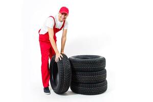 travail homme dans plein croissance détient une pneu sur une blanc Contexte photo