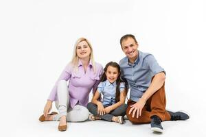 content Jeune famille avec jolie enfant posant sur blanc Contexte photo