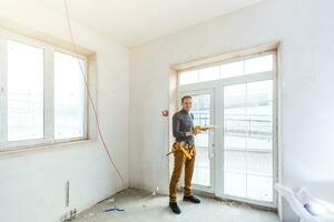 ouvrier du bâtiment installant une fenêtre dans la maison photo