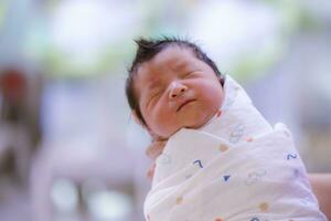 le bébé garçon a été juste née avec bébé tissu enveloppé autour le entier corps photo