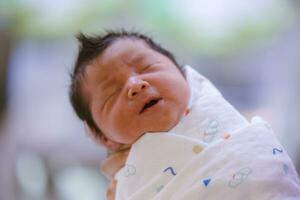 le bébé garçon a été juste née avec bébé tissu enveloppé autour le entier corps photo