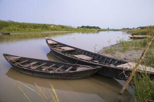 paysage vue de traditionnel en bois pêche bateaux sur le rive de le padma rivière dans bangladesh photo